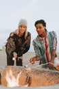 Couple roasting marshmallows over a bonfire