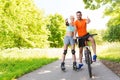 Couple on rollerblades and bike showing thumbs up Royalty Free Stock Photo