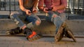 Couple on rollerblades is sitting.