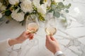 Couple on romantic date. Friends clinking glasses, top view. White wine, flowers around on marble table. Wedding celebration, Royalty Free Stock Photo