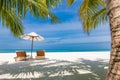 Couple romantic honeymoon anniversary getaway. Tropical Mediterranean resort, two chairs umbrella under palm trees Royalty Free Stock Photo