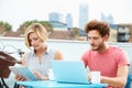 Couple On Roof Terrace Using Laptop And Digital Tablet Royalty Free Stock Photo