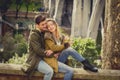 Couple with rose in love kissing on street alley celebrating Valentines day with passion sitting on city park Royalty Free Stock Photo