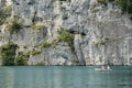 Couple in rowing boat on lake Koenigssee with huge rock face