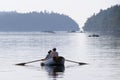 Couple rowing a dinghy in Princess Bay, Wallace Island, Gulf Islands, British Columbia