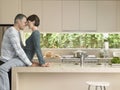 Couple Rubbing Noses In Kitchen Royalty Free Stock Photo