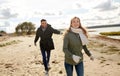 Couple running along autumn beach Royalty Free Stock Photo