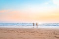 Couple running on the beach. Happy couple go to swim in ocean at sunset. Blurred summer vacation background. Defocused man and Royalty Free Stock Photo