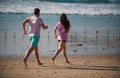 Couple running on beach. Running people jogging on beach exercising and jogging training. Sport runners working out on Royalty Free Stock Photo