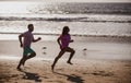 Couple running on beach. Silhouette of young man and woman running jogging along the sea. Royalty Free Stock Photo