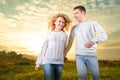 Couple running laughing and holding hands under the sky Royalty Free Stock Photo