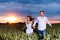 Couple is running over grainfield at night Royalty Free Stock Photo
