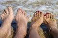A couple`s feet on the background of the sea.