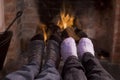 Couple's feet warming at a fireplace