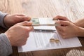 Couple`s Hand Holding Currency Over The Divorce Agreement Royalty Free Stock Photo