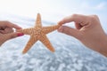 Couple`s hands holding starfish at the beach Royalty Free Stock Photo