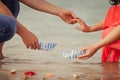 Couple`s hands with paper ships as a simbol of making a wish