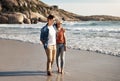 Couple, sand and walking on beach with hug for sunshine, holiday romance, love together and honeymoon. Woman, man and