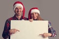 Couple in Santa hats with banner Royalty Free Stock Photo