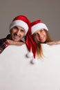 Couple in Santa hats with banner Royalty Free Stock Photo