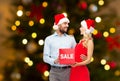 Couple in santa hats with sale sign on christmas Royalty Free Stock Photo