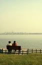 Couple sat on bench by lake