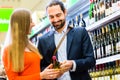 Couple selecting wine in market