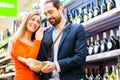 Couple selecting wine in supermarket