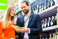 Couple selecting wine in supermarket