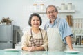 Couple senior Asian elder happy living in home kitchen. Grandfather hug grandmother with happiness and smile enjoy retirement life Royalty Free Stock Photo