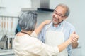 Couple senior Asian elder happy living in home kitchen. Grandfather hug grandmother with happiness and smile enjoy retirement life Royalty Free Stock Photo