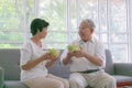 Couple senior eating salad in living room. Delicious and healthy breakfast on the summer day