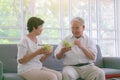 Couple senior eating salad in living room. Delicious and healthy breakfast on the summer day