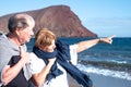 Couple of senior people enjoying the sea in winter.  Horizon over water.  Windy day at the beach with a blue water and blue sky Royalty Free Stock Photo