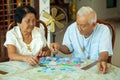 Couple senior playing with a jigsaw puzzle at home Royalty Free Stock Photo