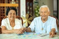 Couple senior playing with a jigsaw puzzle at home Royalty Free Stock Photo