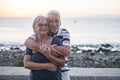 Couple of seniors hogging at the beach with a lot of love - retired together - woman with glasses and man with sea background Royalty Free Stock Photo