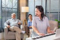 Couple Seniors playing piano and singing songs having fun together happily at home Royalty Free Stock Photo