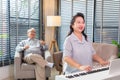 Couple Seniors playing piano and singing songs having fun together happily at home Royalty Free Stock Photo