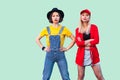 Couple of serious beautiful stilysh hipster best friends in fashionable clothes standing, posing with proud and serious faces and Royalty Free Stock Photo