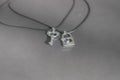 Couple set pendant necklace with a key and a lock for lovers shoot outdoors in a sunny day closeup. Selective focus
