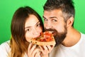 Couple sharing pizza and eating together. Young hipster male and female couple home eating pizza snack. Beautiful loving Royalty Free Stock Photo