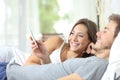 Couple sharing a smart phone on the bed