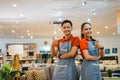 a couple of shop assistants with thumbs up in a furniture store