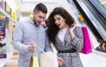 Couple of shopaholics. Man and woman looking into shopping bag Royalty Free Stock Photo