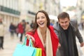 Couple of shoppers running with shopping bags