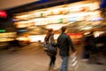 Couple with shopping bags walking past at dusk