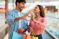 Couple Shopping Making Fingers Heart Holding Shopper Bags In Mall