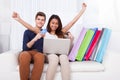 Couple Shopping Online With Bags On Sofa Royalty Free Stock Photo