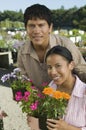 Couple Shopping at Plant Nursery holding flowers portrait Royalty Free Stock Photo